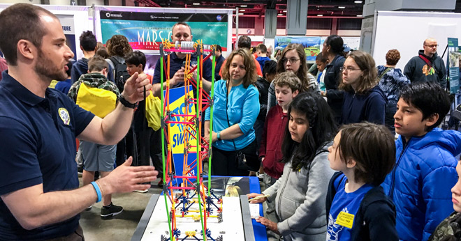 An ASCE member volunteering at a science and engineering festival for k-12 students.