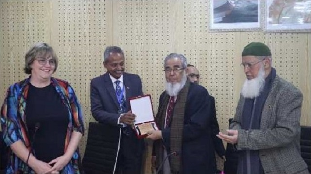 Section leaders presented crest to President Maria and Governor Kamal. Pictured are 4 people smiling in a room. 