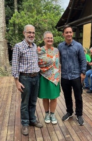 Three people are standing outside smiling at the camera.