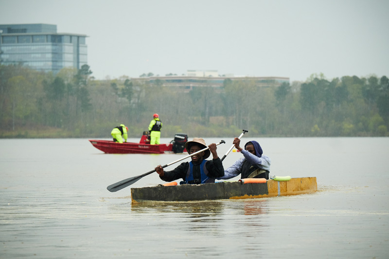 Student members in a canoe at ASCE Concrete Canoe Competition.