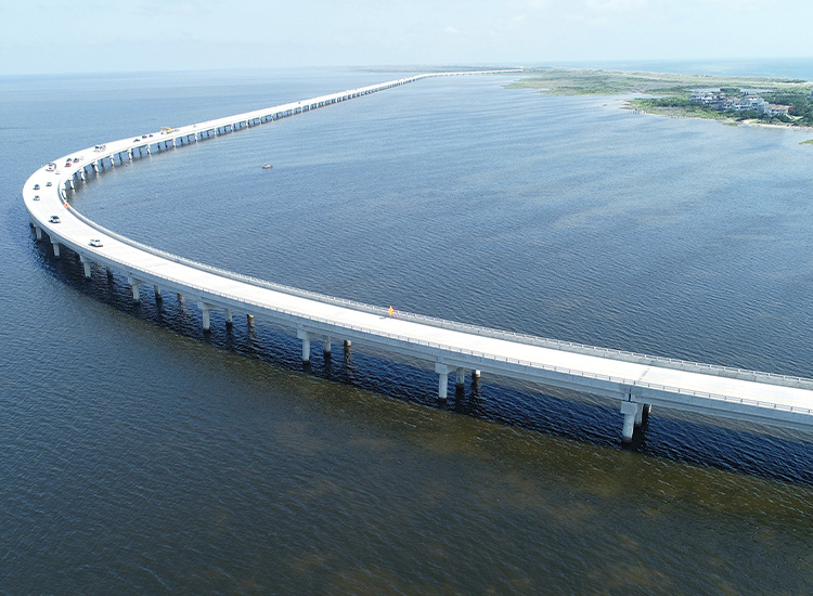 Uniquely shaped bridge curves over a large body of water. 