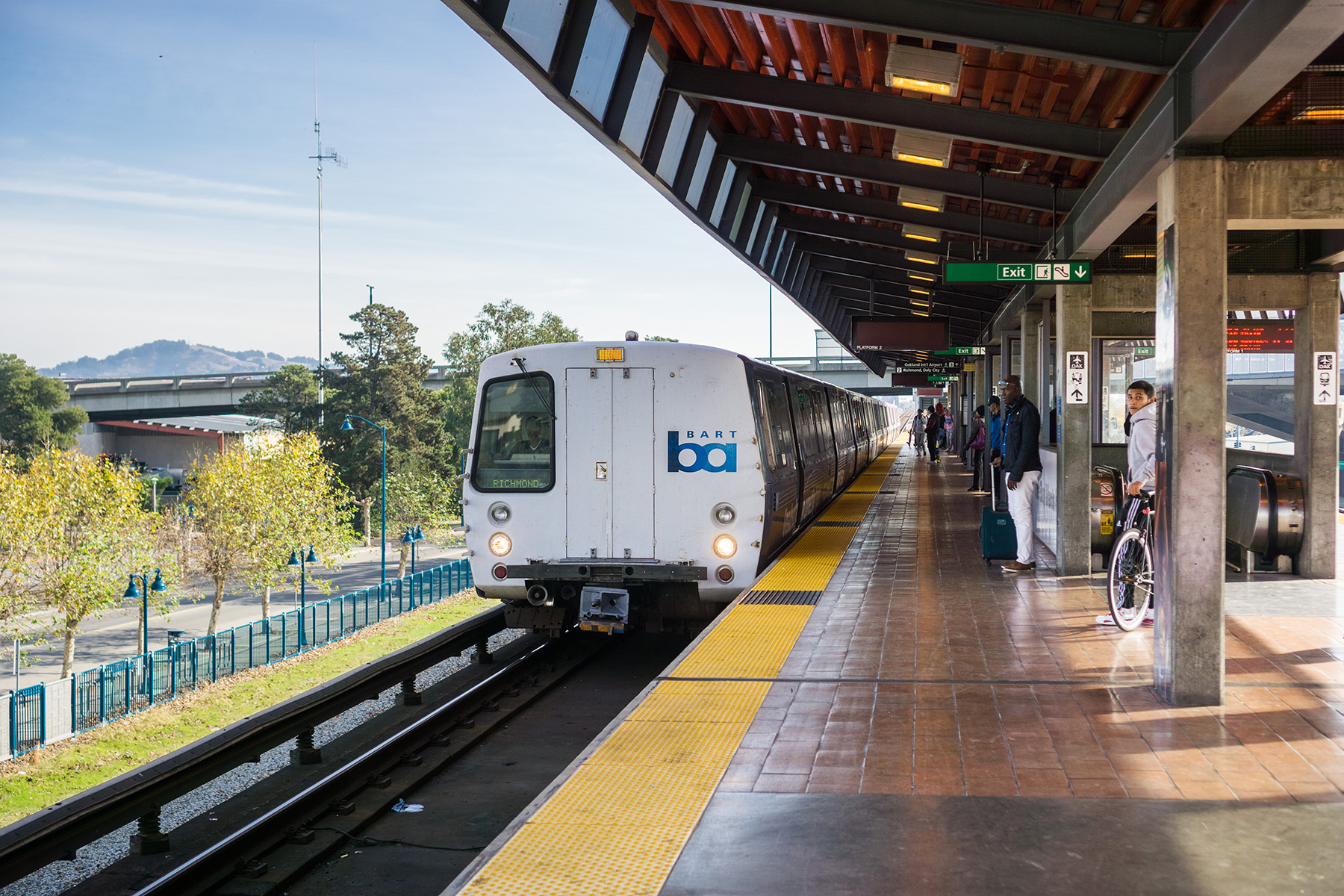 train on a platform while people wait to board it 