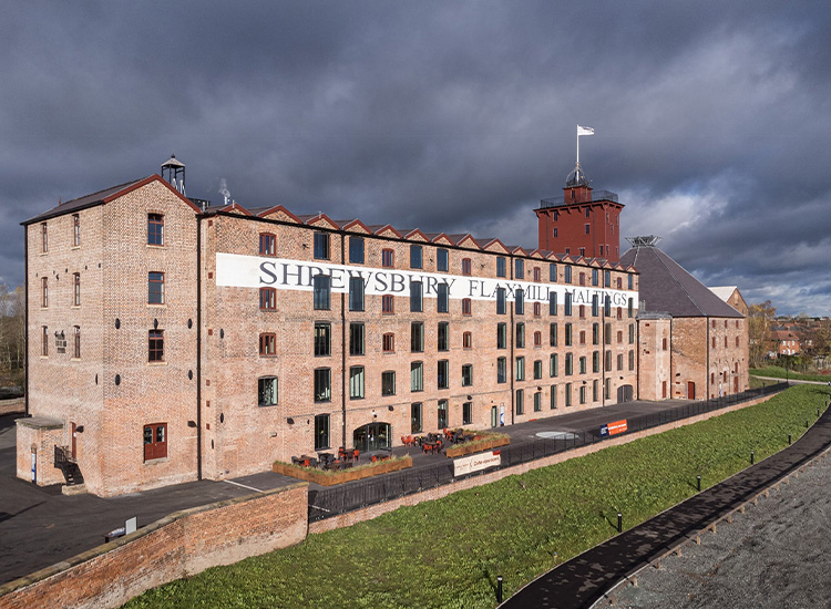 Multistory brick building with the words “Shrewsbury Flaxmill Maltings” written on the side.