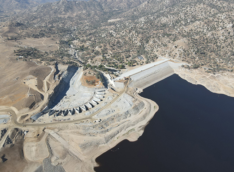 Aerial photograph of a dam surrounded by a barren landscape. 