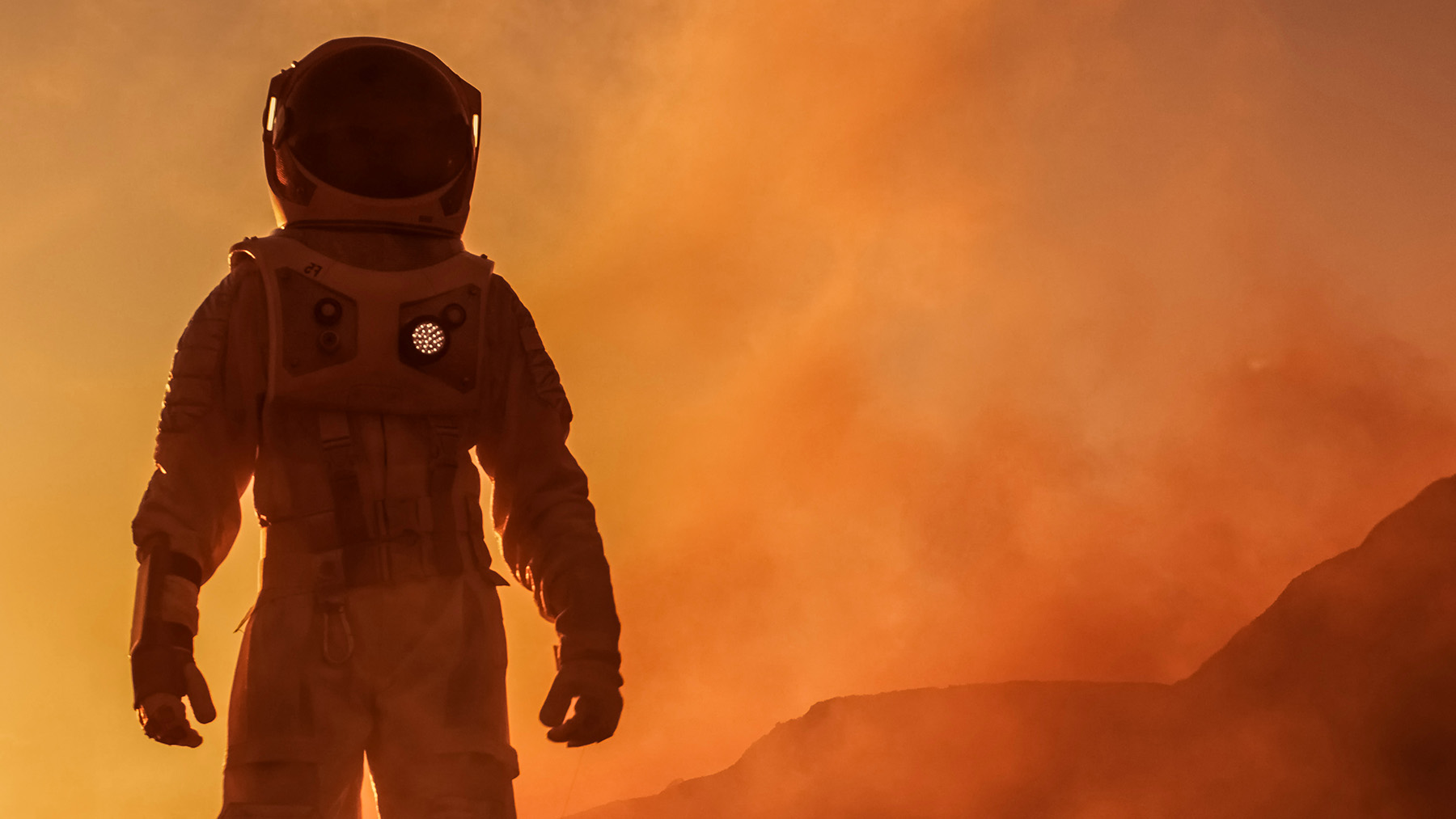 A person in a spacesuit faces the camera.