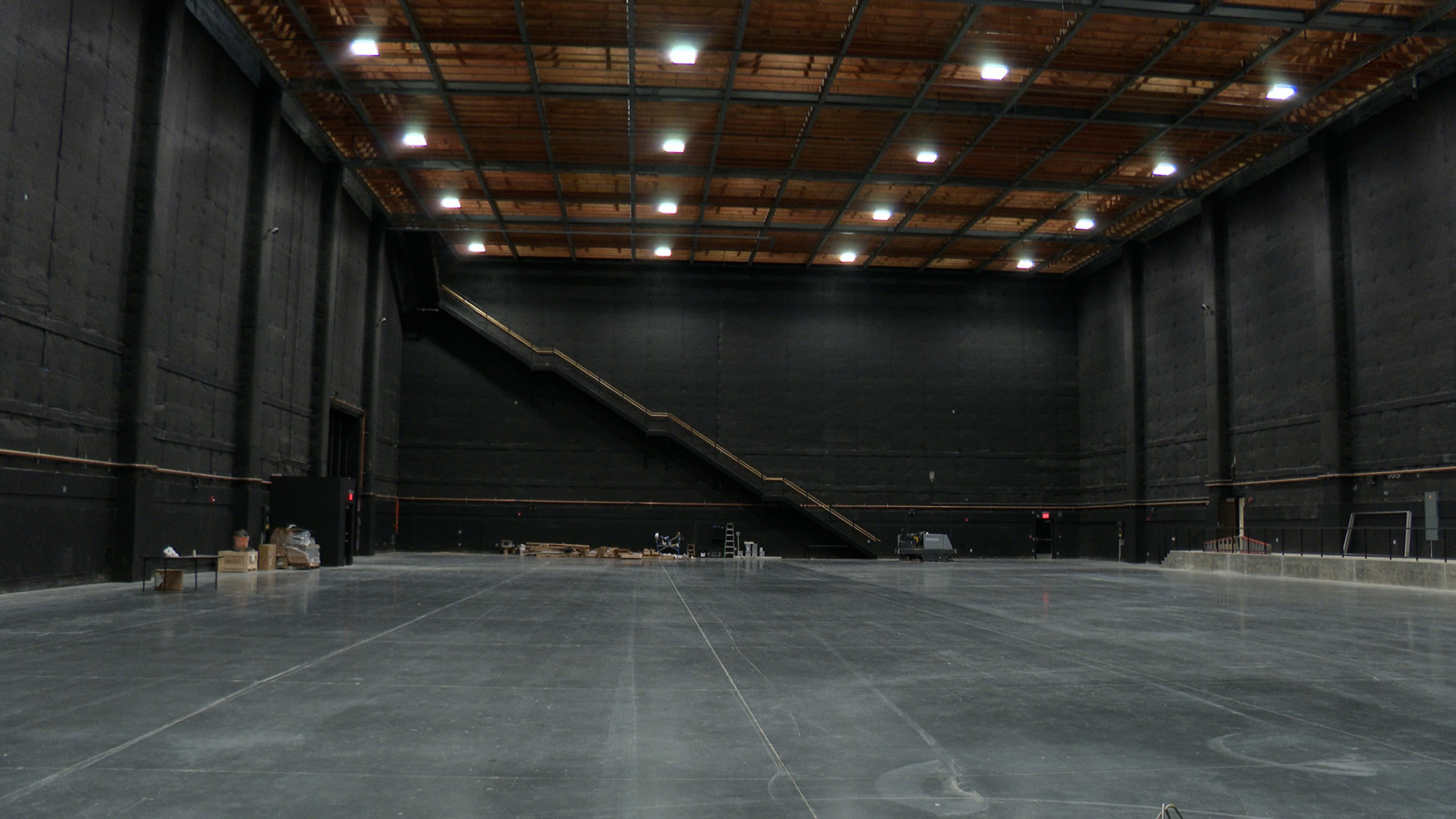The photograph shows the large, open space of a studio building that will be used for soundstages.