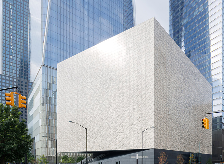 Street view of a light-colored, square building. 