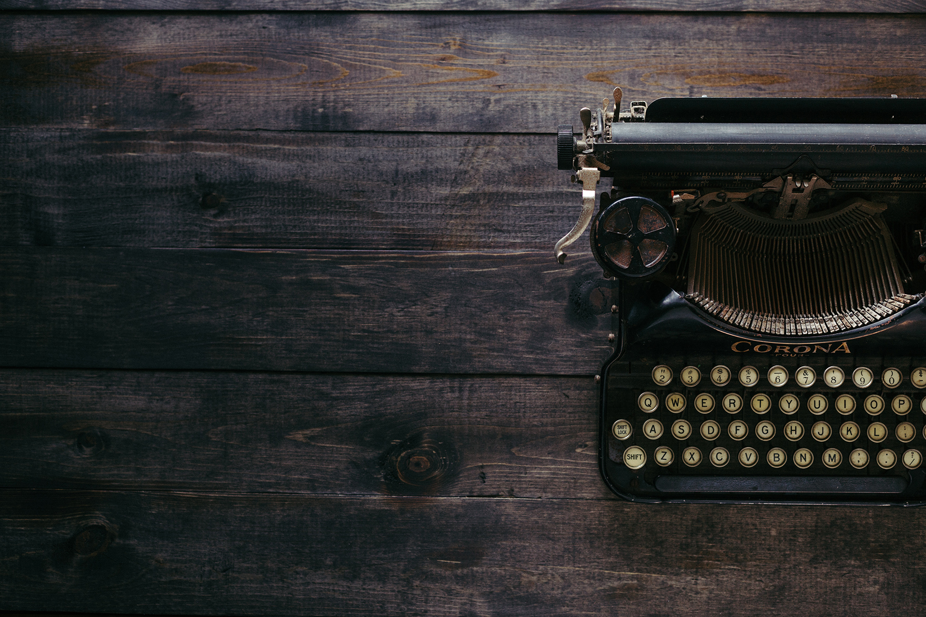 ANTIQUE TYPEWRITER ON WOODEN DESK