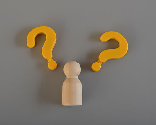 Wooden figure and question mark symbols