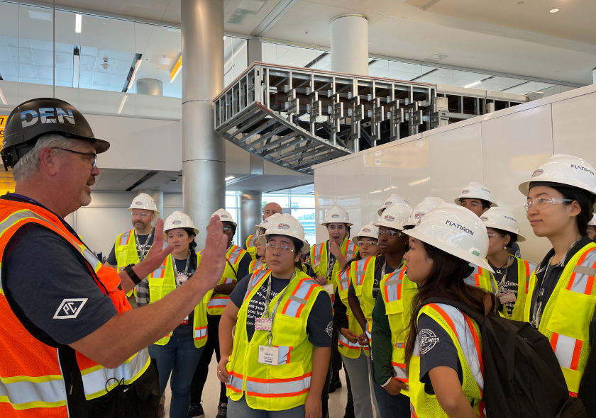 Young people getting a safety briefing from a worker.